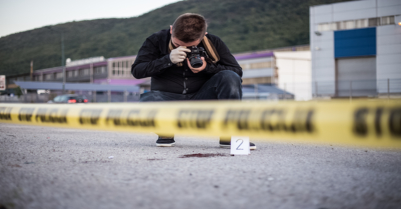 Blood Spatter Analyst Taking Pictures at a Crime Scene