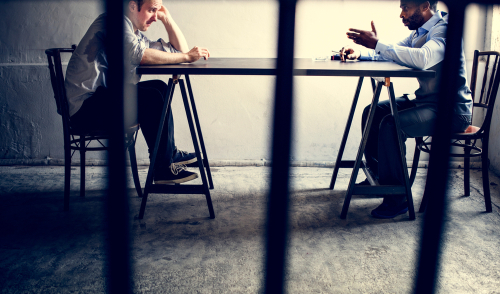 Police detective interrogating suspect at a table