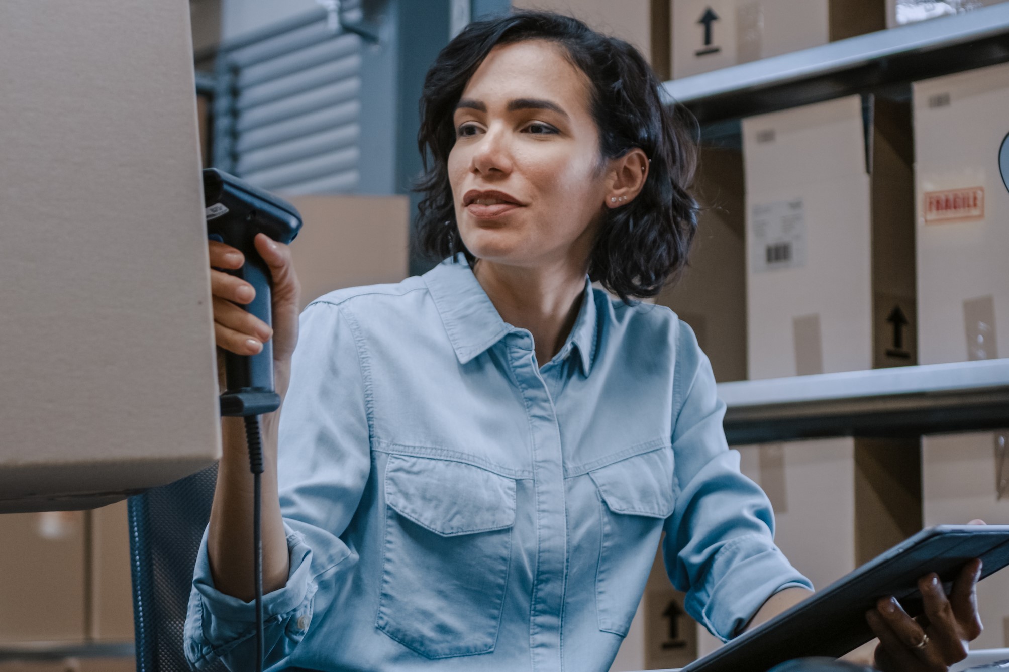 Postal Inspector Scanning Packages in Warehouse