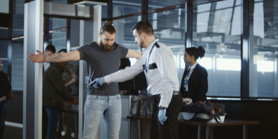 transportation security officer ensuring passenger is clear of weapons