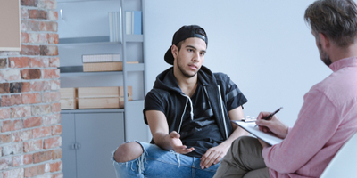 boy and juvenile court register talking in a juvenile detention center