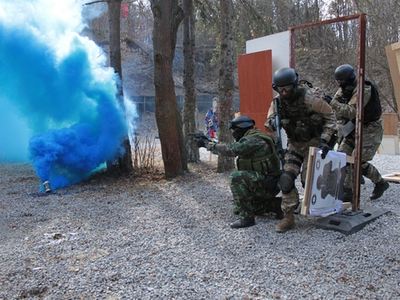 Men in camo running around blue smoke bomb