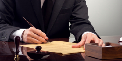 Businessman signing paper at a desk