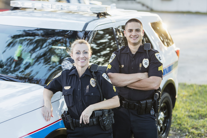 Policewoman and partner next to squad car